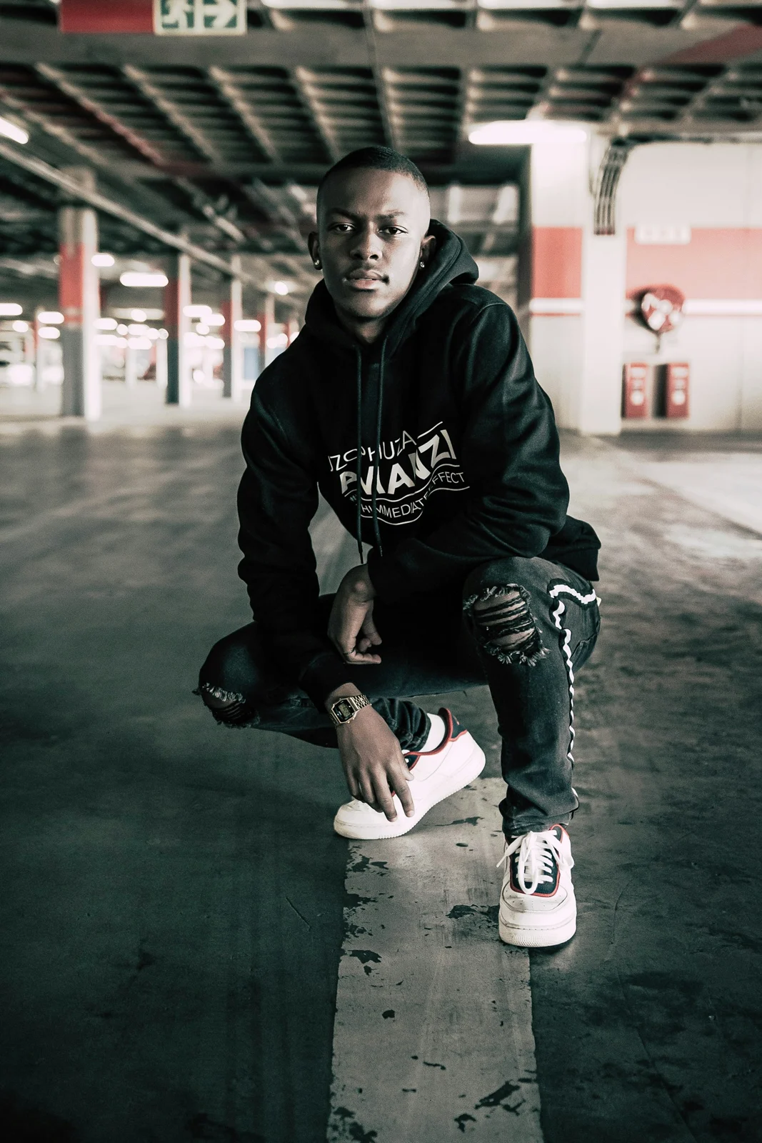 Streetwear portrait in Johannesburg, in a black hoodie and sneakers